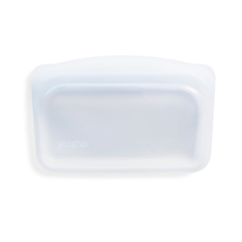 The Stasher Snack Bag is a reusable, transparent silicone snack bag with a frosted finish, rounded edges, and a top seal. The brand name "stasher" is subtly embossed on the front.